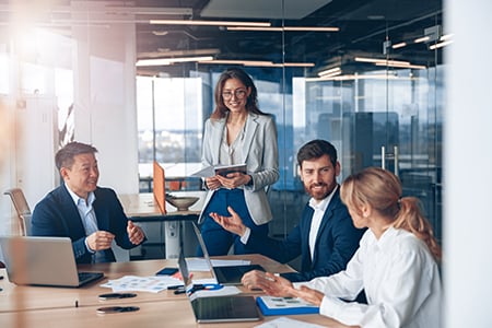 Business leader presenting documents to team in modern office