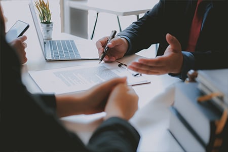 Colleagues collaborating on documents at meeting table
