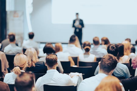 Business speaker giving a talk at business conference event.